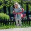 Mała dziewczynka huśta się na czerwonej huśtawce Huśtawka 1+2 w parku.
