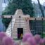 Drewniany domek dla dzieci Wigwam z huśtawką na placu zabaw.