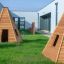 Drewniane domki dla dzieci typu Wigwam na placu zabaw.