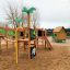 Drewniany plac zabaw Domek Britty z zjeżdżalnią i domkiem na plaży.