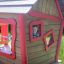 chłopiec bawiący się w drewnianym domku na placu zabaw