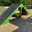 Zielono-brązowy namiot dla dzieci z tablicą wspinaczkową na placu zabaw.