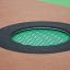 Trampolina okrągła 100 cm z zieloną siatką i czarną osłoną na gumowej powierzchni placu zabaw.