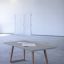 Stół betonowy InsideOut Concrete z drewnianymi nogami w nowoczesnym wnętrzu.