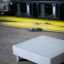 InsideOut Concrete Stolik z betonu na kółkach w surowym, przemysłowym otoczeniu.