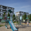 Mały odkrywca ze ścianką wspinaczkową na nowoczesnym placu zabaw zjeżdżalnia i drabinki.