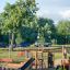 Drewniany plac zabaw Mała Dżungla Nature z czarną zjeżdżalnią i siatką wspinaczkową.