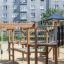 Plac zabaw King-Kong Nature II z drewnianymi elementami i zjeżdżalnią na piaskowym podłożu