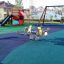Wielofunkcyjna huśtawka na placu zabaw Wetpour 80 z miękką nawierzchnią w bezpiecznym, miejskim otoc