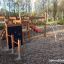 Plac zabaw Pantera z huśtawkami, zjeżdżalnią i ścianką wspinaczkową, umieszczony na żwirowym podłożu
