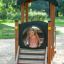 Dziewczynka bawi się na drewnianym placu zabaw Lokomotywa Nature na zewnątrz.