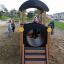 Dzieci bawiące się na placu zabaw na drewnianej zjeżdżalni Lokomotywa Nature.