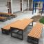 Drewniane ławki Kyoto z metalowymi podstawami na placu szkolnym.