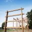 Duża drewniana drabinka wysoka na placu zabaw z huśtawkami i linami, idealna dla dzieci.