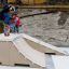 Młody skateboardzista wykonuje trik na rampie Jump-Ramp w parku miejskim.
