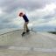Chłopiec na deskorolce wykonuje trik na rampie skateparku.